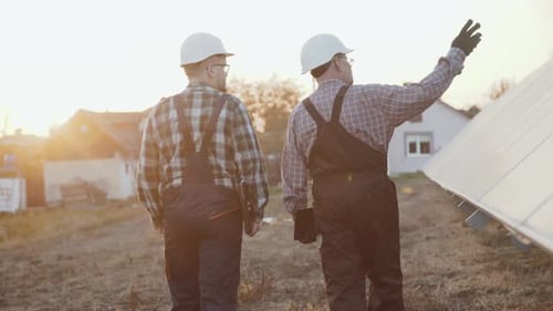 Two Factory Engineers Walking and Analyzing Construction of Solar Batteries