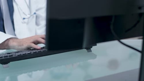 Arzt tippt auf der Computertastatur
