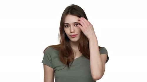 Smiling Woman Smooths Hair on White Background
