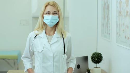 Retrato de una bella doctora en medicina profesional caucásica con máscara médica de pie en su