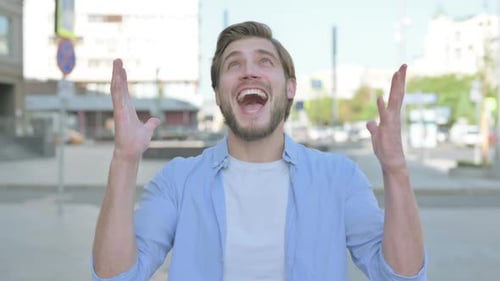 Excited Man Celebrating Success on City Street