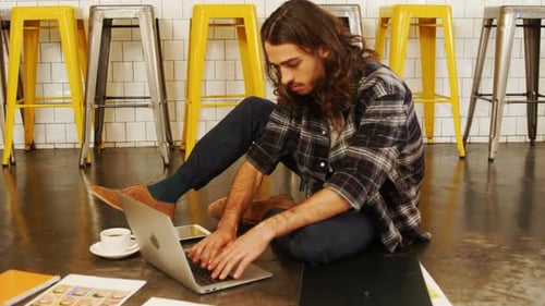 Young Man Working on Laptop in Urban Workplace