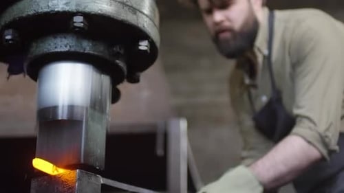 Man Forging Metal with Heavy Industrial Press