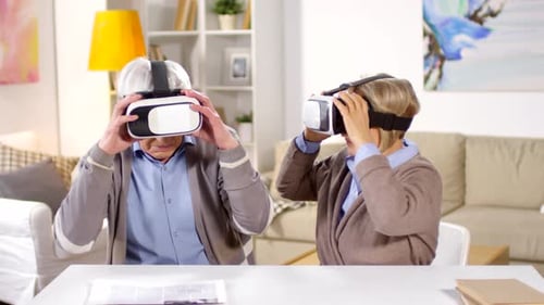 Senior Couple Uses VR Headsets in Living Room