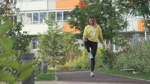 Woman Warming Up Leg in Park