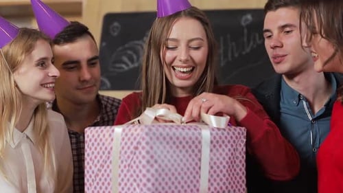 Friends Celebrate Birthday with Present and Party Hats