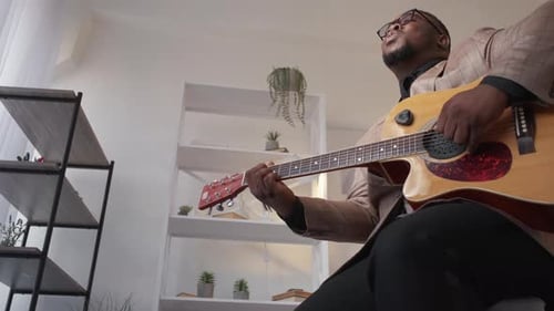 Man Playing Acoustic Guitar Indoors