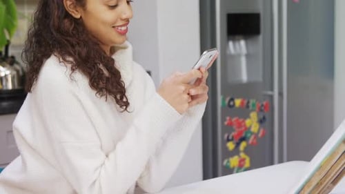 Woman Using Smartphone at Kitchen Table Indoors