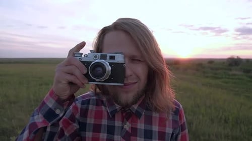 Man with Vintage Camera Outdoors at Sunset