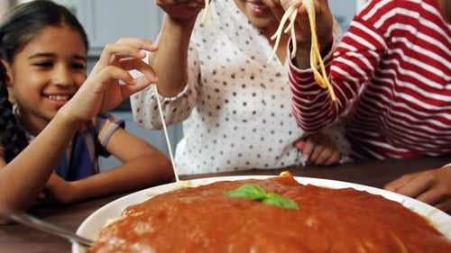 Family Enjoys Spaghetti Meal Together at Home