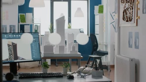 Niemand im Büro mit Gebäudemodell und Maquette auf Tisch 3D Baustelle auf Monitor