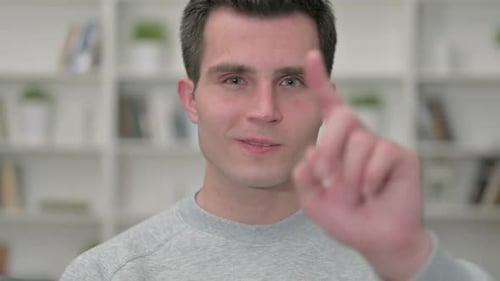 Young Adult Man Points and Smiles Close Up