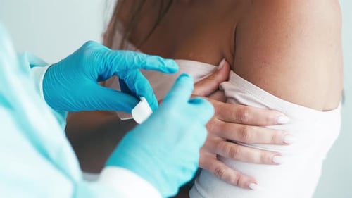 Healthcare Provider Applies Bandage to Patient's Arm