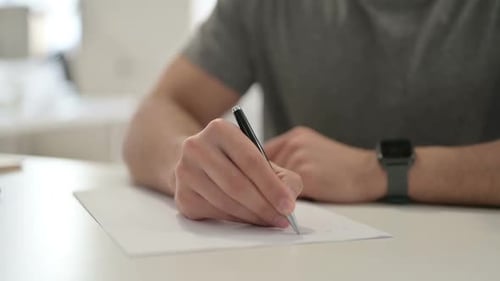 Hände des jungen Mannes auf Papier schreiben Nahaufnahme