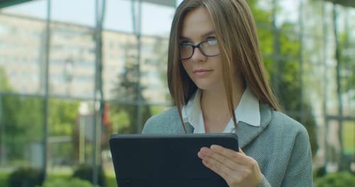 Young Woman Uses Tablet Outdoors