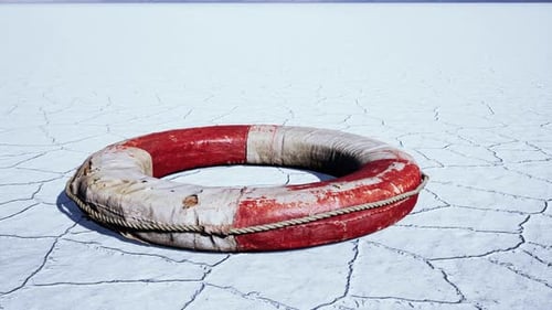 Worn Lifebuoy on Cracked Arid Landscape with Distant Mountains