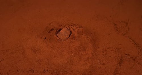 Chocolate Truffle falling on Chocolate Powder, slow motion 4K
