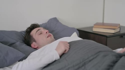 Homme se réveillant de son sommeil au lit