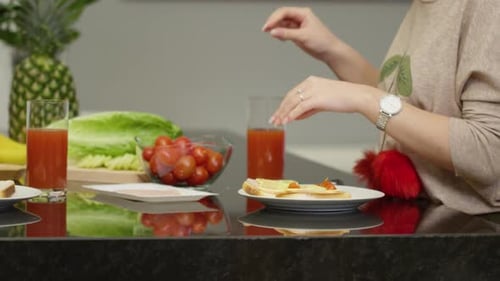 Woman Prepares Tomato and Cheese Sandwich in Kitchen