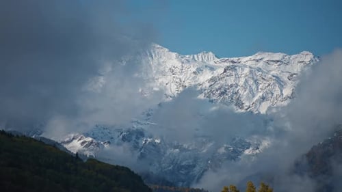 Snowy Mountains Partially Obscured by Rolling Fog