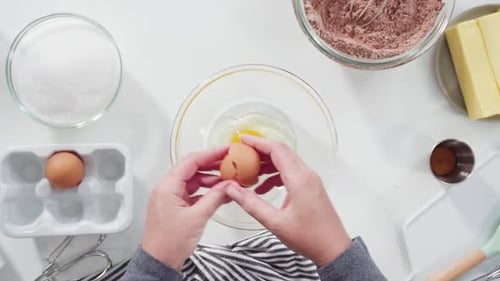Woman Cracks Eggs into Bowl for Baking