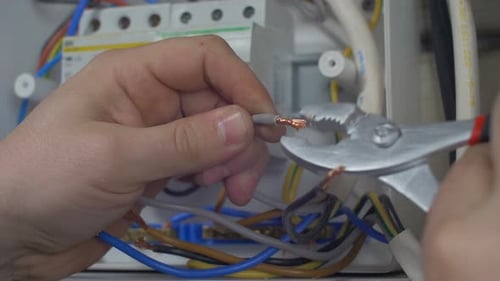Electrician adjusting a Copper Wire with Pliers