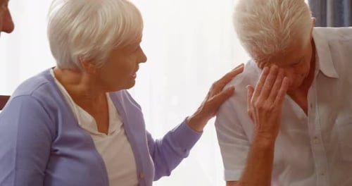 Woman Comforts Man in Group Setting
