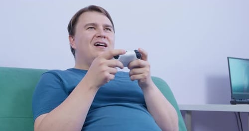 Excited Young Adult Playing Video Game at Home
