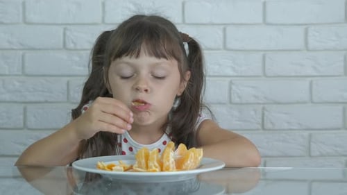 The child eats tangerine.