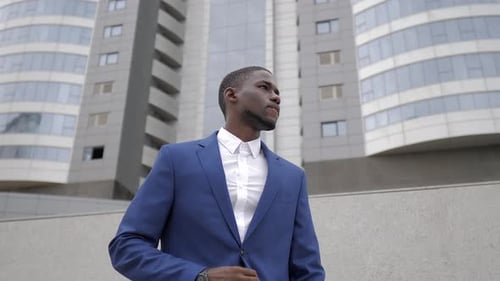 Stylish Man in Blue Suit Checks Time Outdoors