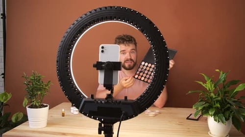 Joven filmando un episodio de su videoblog sobre nuevos productos cosméticos
