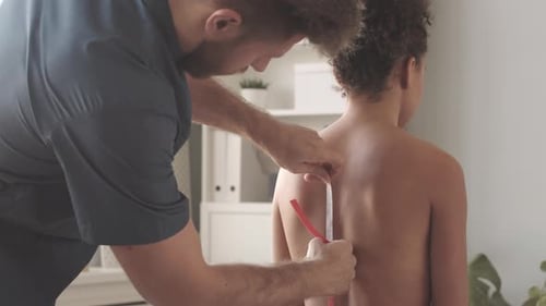 Doctor Measures Child's Spine in Bright Office