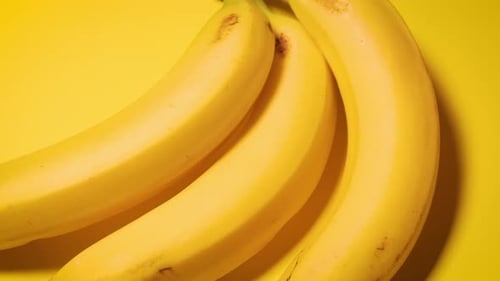 Frische Bananen auf gelbem minimalistischem Hintergrund
