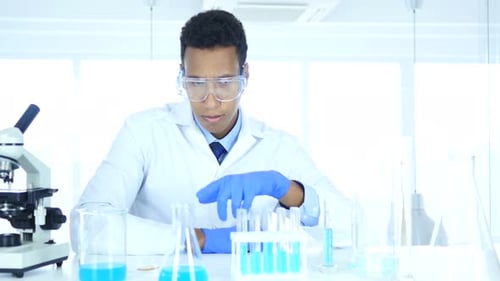 Young Adult in Lab Examines Scientific Equipment