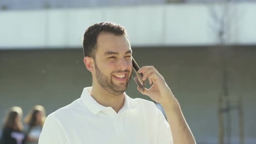 Smiling Man Chatting on Phone in Urban Setting