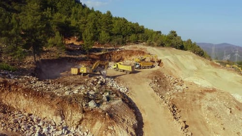 Bagger und Muldenkipper arbeiten im Steinbruch von Mountains Mining