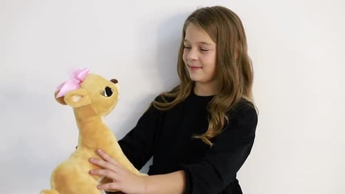 Girl Hugging Stuffed Animal Deer Toy Indoors