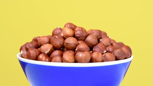 Noisettes dans un bol rotatif sur fond jaune