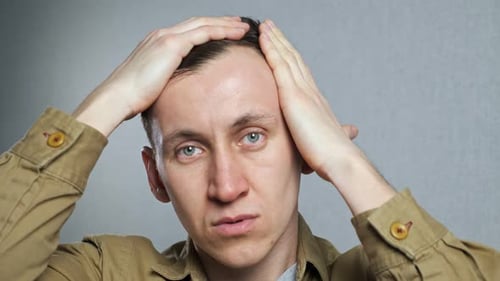 Worried Man Inspects Thinning Hairline in Close Up