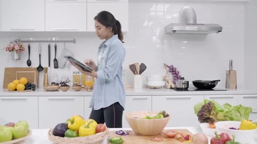 Woman Uses Tablet in Bright Kitchen