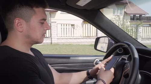 Young Adult Using Smartphone in Car