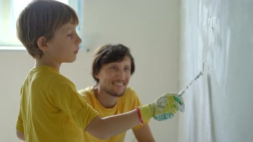 Boy Smoothing Plaster on Wall with Adult Supervision