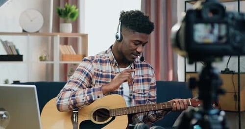 Young Man Playing Guitar and Recording Video
