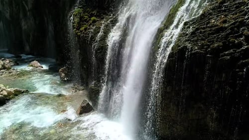 Scenic Waterfall Cascading into Turquoise Stream