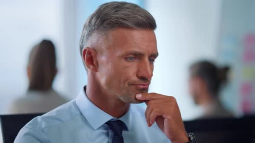 Man Thinking in Office Wearing Blue Shirt