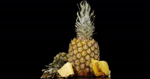 O
abacaxi fatiado e inteiro com verduras gira lentamente.