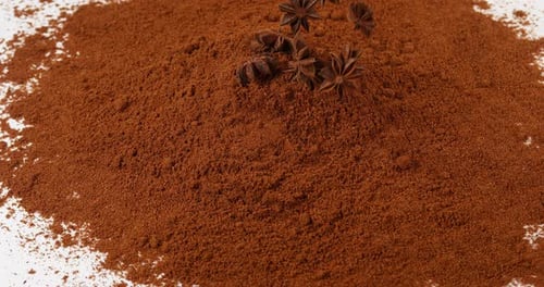 Star Anise Falling on Cocoa Powder in Studio