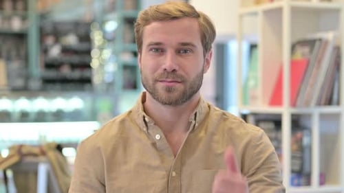 Young Adult Smiling and Giving Thumbs Up