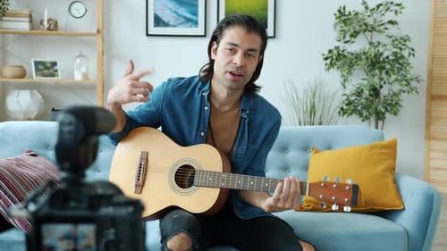 Musician Playing Guitar and Recording Video at Home