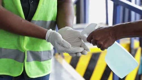 Indian Asian Construction Workers Use Hand Sanitizer